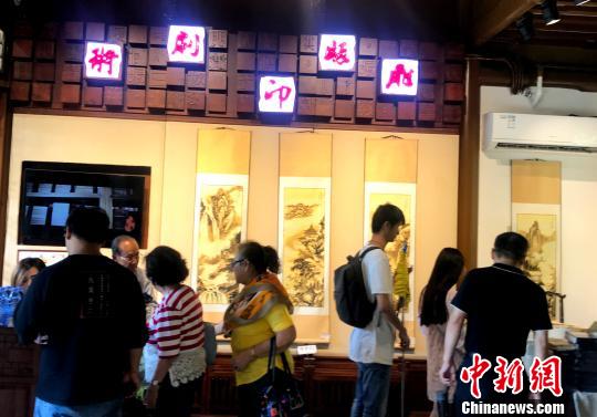 图为中外游客近距离感受非遗文化。　崔佳明 摄