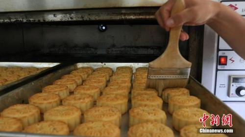 资料图：给定形月饼刷蛋液，保证月饼的色泽和口感。程鹏翔 摄