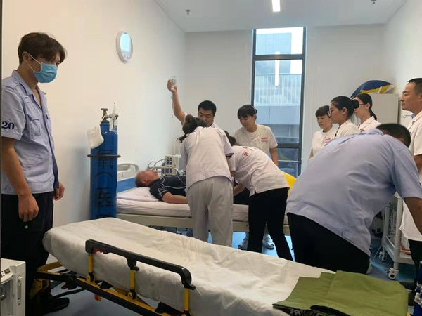 图为9月17日下午3时许，北京冬奥组委办公区“红十字救护站”医护人员、“红十字博爱救护队”队员协同赶来的急救车医务人员对患者进行有关检测和处理