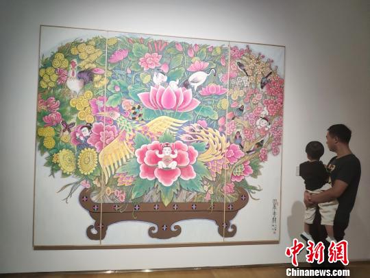一位父亲带着孩子观看展览。　唐小晴 摄