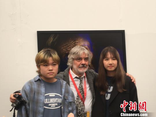 弗拉基米尔·维亚特金与年轻摄影爱好者交流。　高雨晴 摄