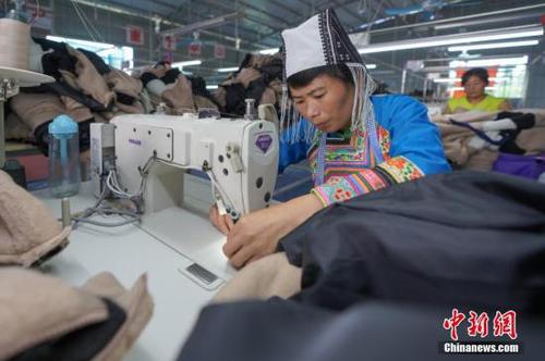 资料图：贵州榕江“扶贫车间”进苗寨助农增收。 中新社记者 贺俊怡 摄