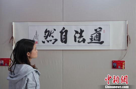 9日，观众在“庆祝中华人民共和国成立70周年——影视艺术家优秀书画作品展”上参观王刚的书法作品《道法自然》。　<a target='_blank' href='http://www.chinanews.com/'>中新社</a>记者 贾天勇 摄
