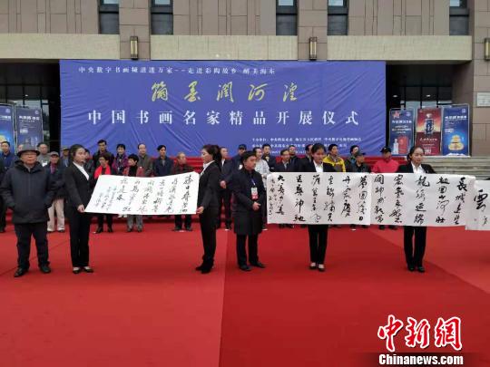 图为书画家在中国书画名家精品开展仪式现场进行书法创作，并展示作品。　鲁丹阳 摄