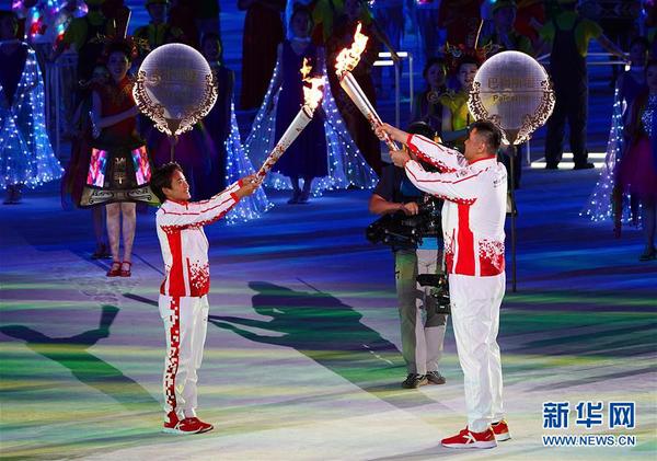 10月18日，第七届世界军人运动会开幕式在武汉体育中心举行。这是火炬手王霜（左）与火炬手刘玉栋在开幕式上交接。新华社记者 金良快 摄