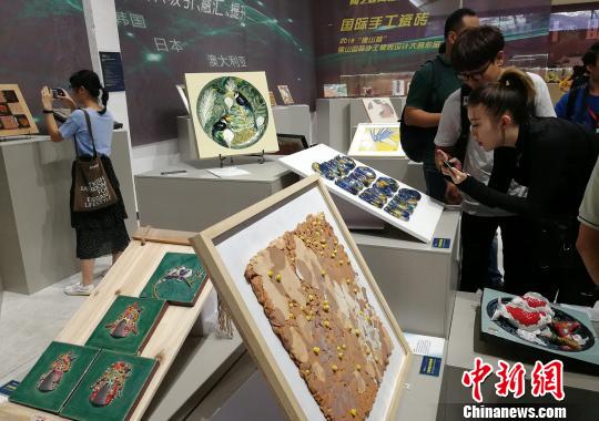市民正在观看展出的手工瓷砖设计作品。　程景伟 摄