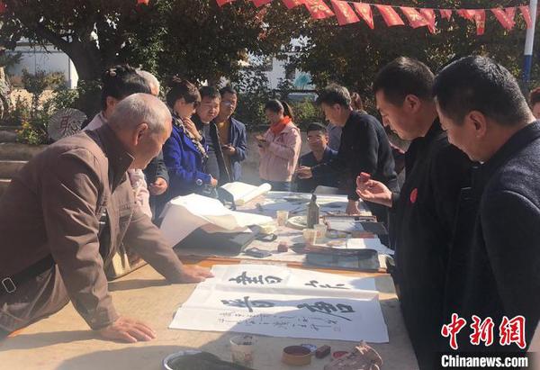 图为文人书写“美丽乡村”。　钟欣 摄