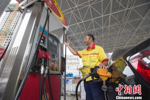 图为山西太原一加油站，工作人员正在加油。中新社记者 张云 摄