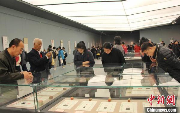 图为观众在展厅内欣赏篆刻作品。　赵晓 摄