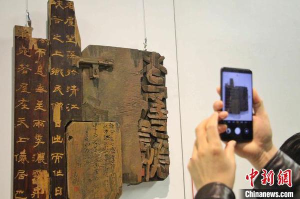 图为观众在刻字作品前驻足拍照。　赵晓 摄