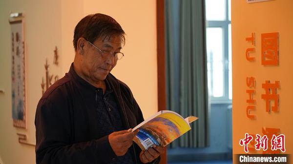 图为社区居民在图书漂流站看书。　魏建军 摄