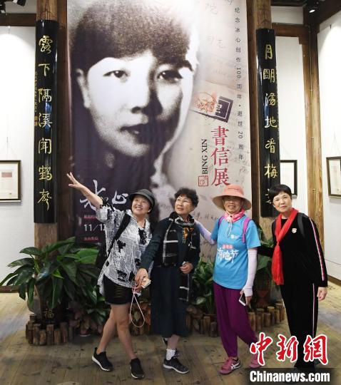 观众在展出的冰心青年时期黑白老照片前合影。　记者刘可耕 摄