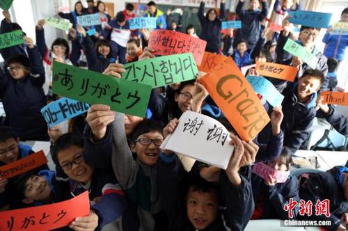 资料图：中学生们用八国语言书写“谢谢”。周小云 摄
