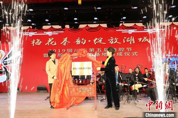 宁夏回族自治区宣传部副部长、宁夏文旅厅党组书记刘军(左)与银川市委常委、宣传部部长李虹(右)为宁夏银川市秦腔传承保护基地揭牌。　李佩珊 摄
