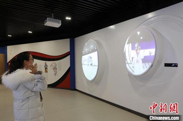 市民在宁夏银川市秦腔传承保护基地体验室内利用投影“换”上秦腔人物行头。　李佩珊 摄