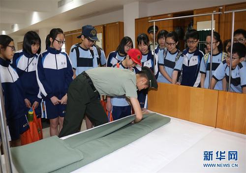 驻澳门部队在军营开放活动中邀请市民走进军营参观，战士们向小学生演示叠军被（2017年8月24日摄）。 新华社发（叶华敏 摄）