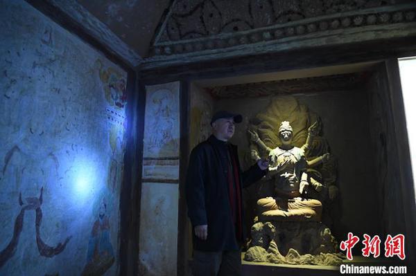 图为许林介绍洞窟壁画及佛头复原过程。　魏建军 摄