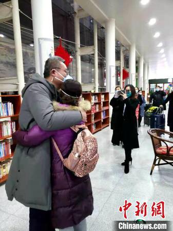 资料图：图为山东首批医疗队深夜集结支援武汉，医护人员出发前和家属拥抱告别。　邱江波 摄