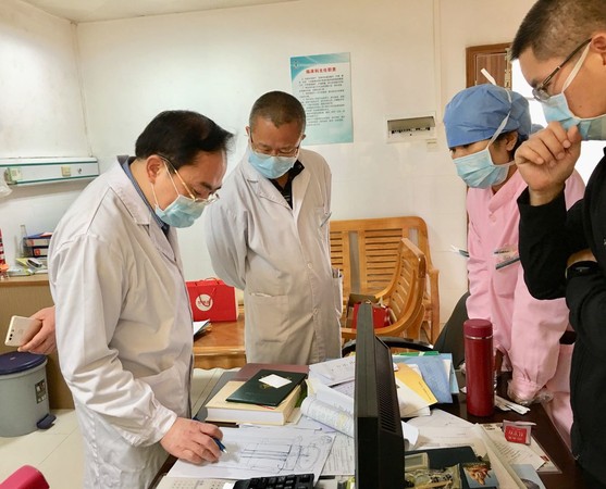 左万里（左一）深入医院感染科一线部署防控工作