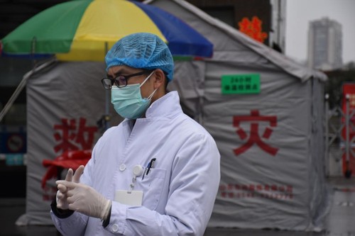戴上一次性手套、一次性口罩、一次性帽子，穿着白大褂的谭晓鹏开始了一天的工作