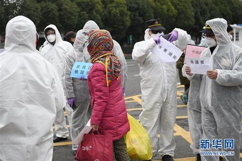 2月11日，社区工作人员将出院患者接回家。 当日，武汉市武昌方舱医院首批新冠肺炎轻症患者经过治疗出院。 新华社记者 程敏 摄