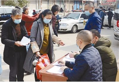 图为老肖夫妇出发前做好登记，准备乘车。