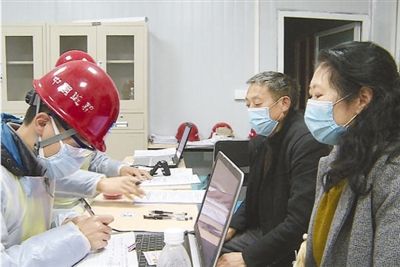 图为老肖夫妇到达工地后办理手续。