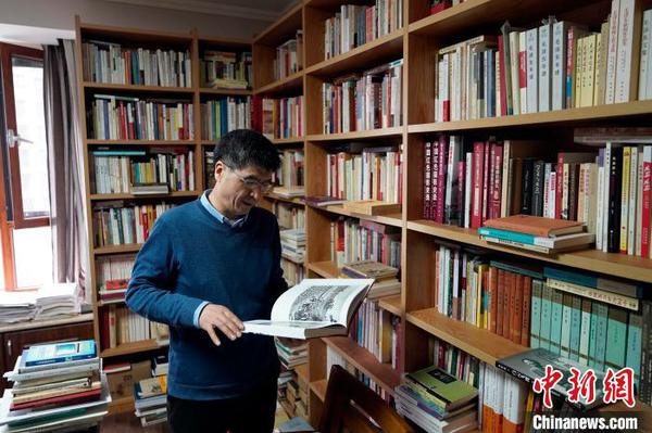 “家里能放书架的地方全部放着满载的书架”。客厅、书房、走廊、卧室甚至阳台都放满了书。　赵彬 摄