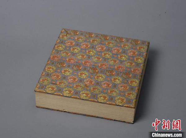 清宫旧藏《大乘喜金刚各佛秘密脉相图》。文物经板上裱有绫面，图案由六边形和方形组成，六边形中有龙纹，方形中为“万”和“寿”字。故宫出版社供图
