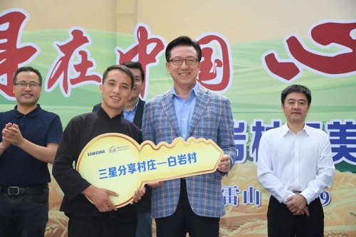 019年9月，“三星分享村庄”贵州雷山县白岩村精品民宿项目竣工，中国三星总裁黄得圭（前右）将“金钥匙”牌交予白岩村村长唐文德（前左）
