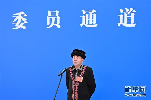 5月24日，在北京人民大会堂新闻发布厅举行全国政协十三届三次会议第二场“委员通道”采访活动。这是全国政协委员玉克赛克·西加艾提通过网络视频方式接受媒体采访。 新华社记者 刘金海 摄