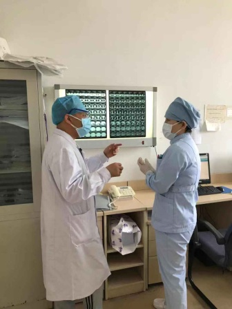 高永明（左）与刘艾（右）讨论患者病情