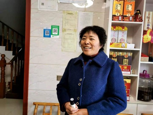 李纪芳向记者介绍民宿经营情况。人民政协网记者付振强 摄