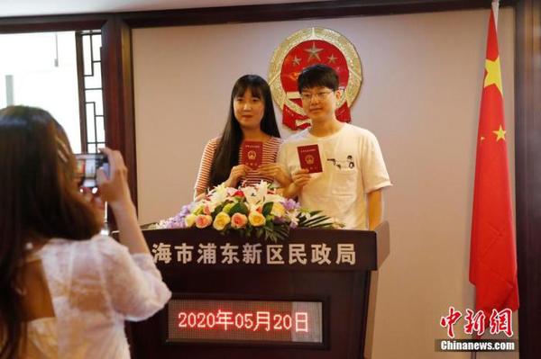 资料图：两位市民手持结婚证合影留念。 殷立勤 摄