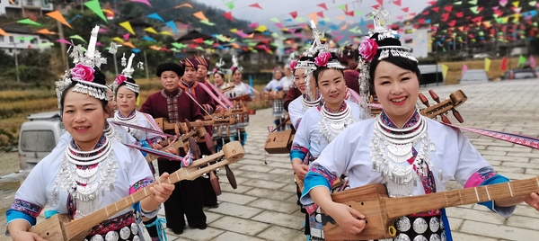 （4月14日，龙胜县龙脊镇金江村，侗族同胞弹唱侗族琵琶歌，欢迎农历三月三。 周恩平摄）