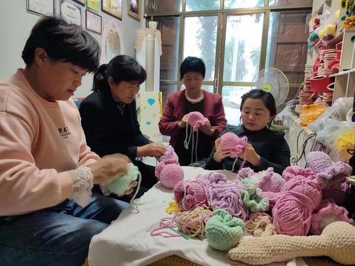 王妙（右一）正在编织作品中国残联供图