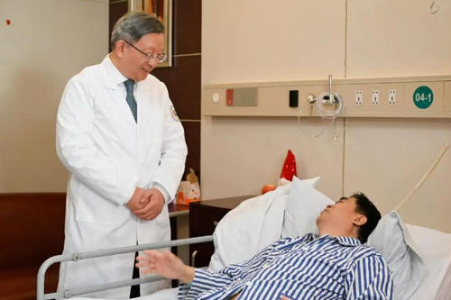 蔡秀军在查房时与患者交流。