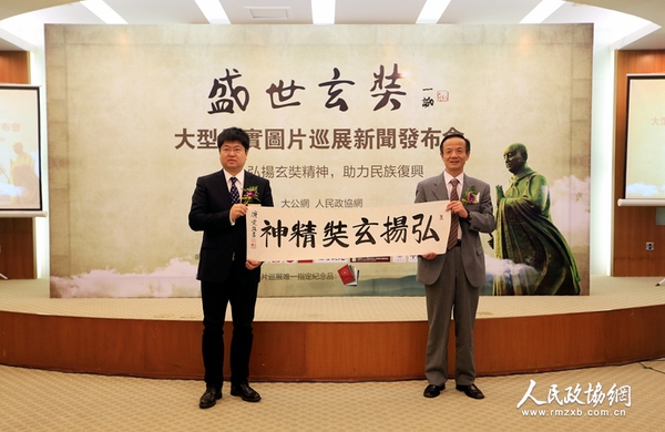 中国佛教协会常务理事陈星桥与大公报社长助理、北京分社社长、大公网执行总裁兼总编辑王文韬展示中国佛教协会驻会副会长演觉法师的墨宝——《弘扬玄奘精神》（摄影：姚勇）